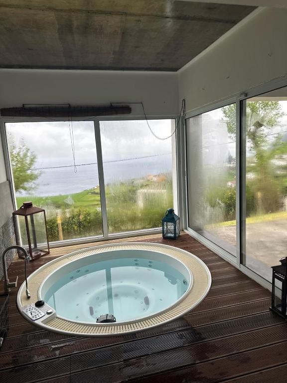 a jacuzzi tub in a room with a large window at Sunrise House Azores - jacuzzi in Senhora da Nazaré