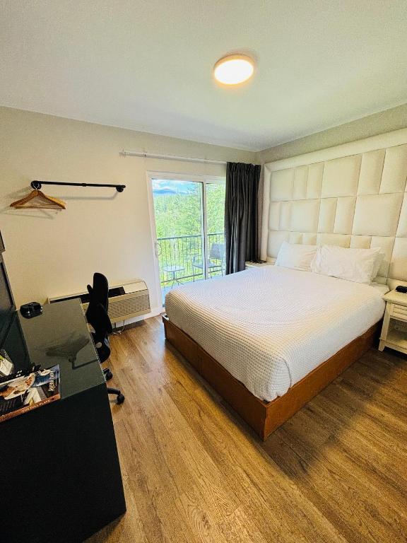 a bedroom with a bed and a desk and a window at Hotel Civilia Lakeside by Civilia Golf Retreat in Clearwater