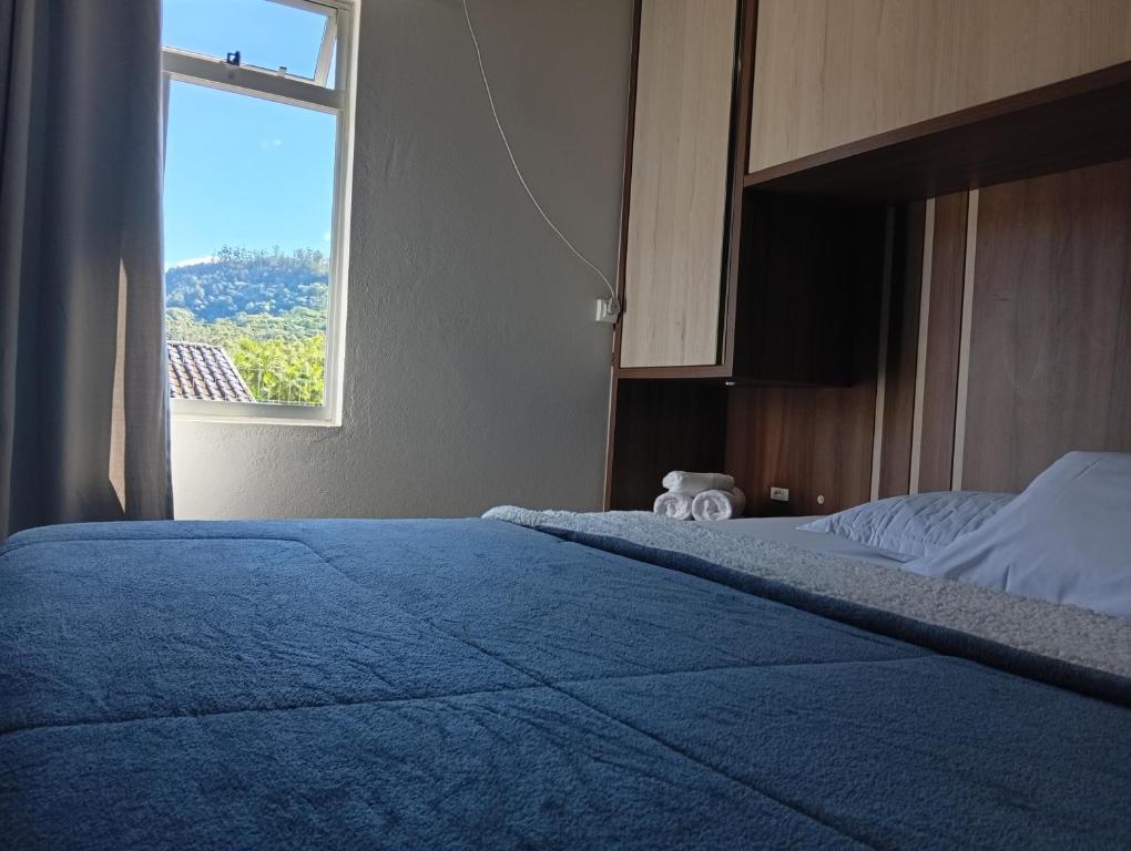 a bedroom with a large bed with a window at Casa Zibell centro de Pomerode in Pomerode