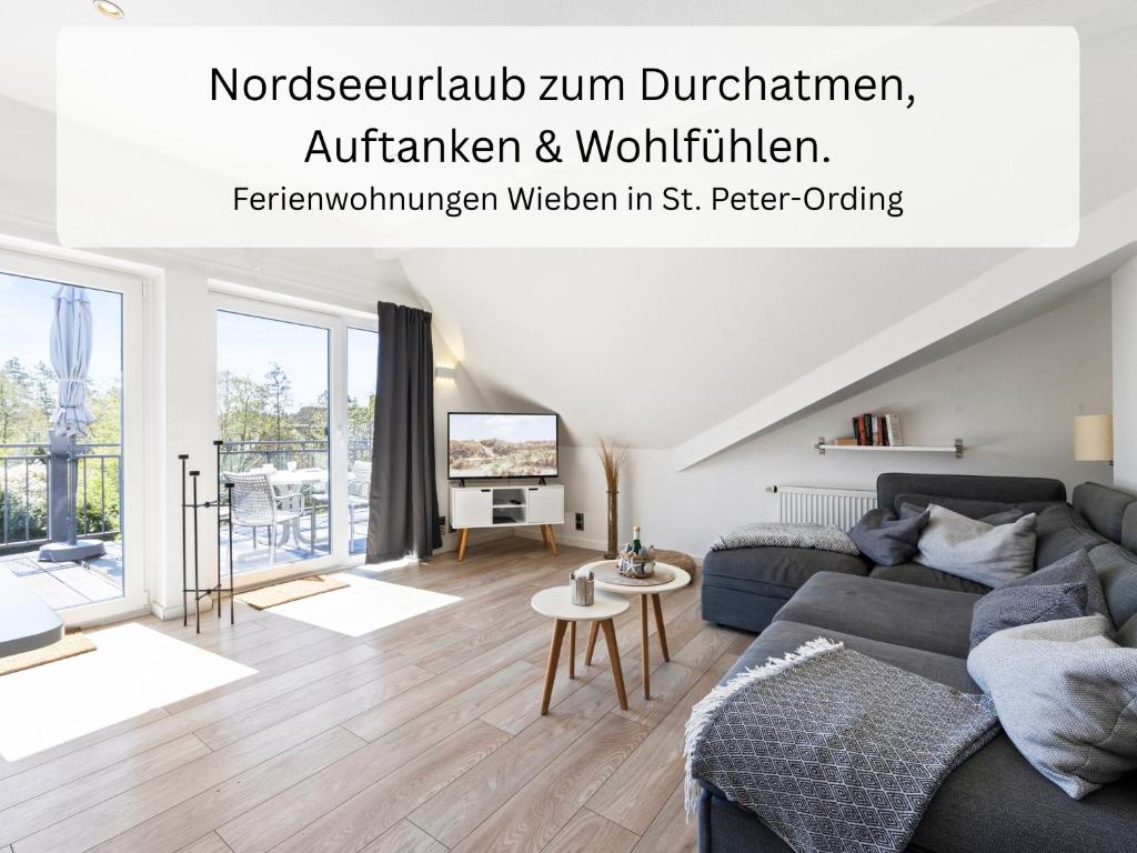 a living room with a couch and a table at Ferienwohnung Wieben Sankt Peter-Ording in Böhl