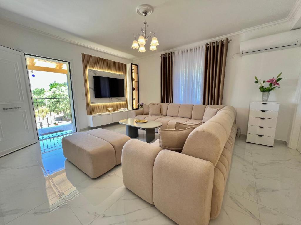 a large living room with a couch and a tv at Villa Joel in Kefallonia