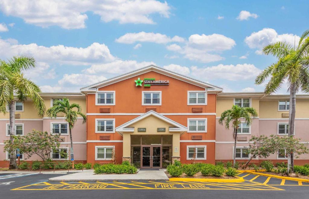 a hotel with palm trees in a parking lot at Extended Stay America Suites - West Palm Beach - Northpoint Corporate Park in West Palm Beach
