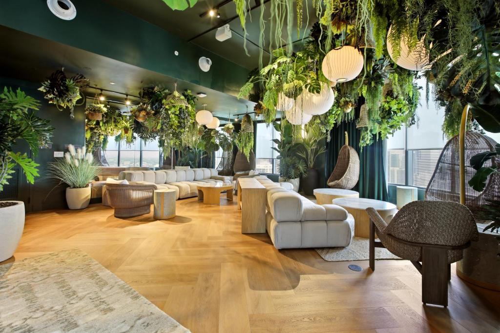 a waiting room with lots of plants and furniture at The York Suite Miami in Miami
