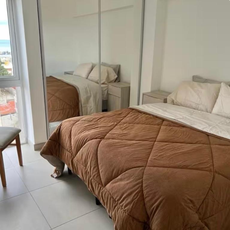 a bedroom with a bed and a mirror at The View Comodoro in Comodoro Rivadavia