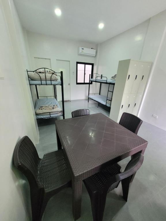 a room with a table and chairs and two bunk beds at MAOS Building in Batangas City