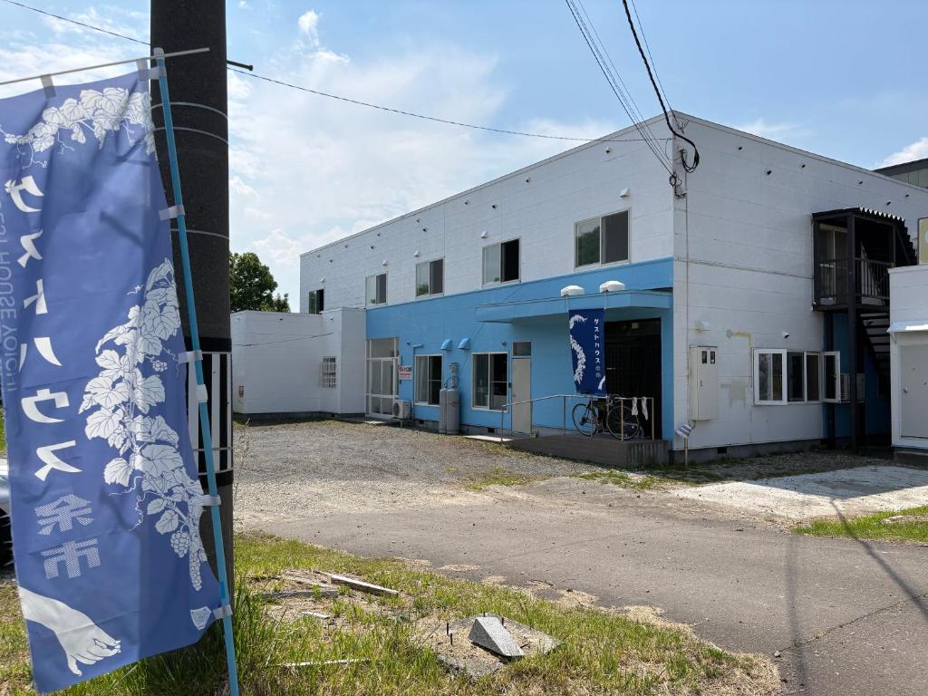 a building with a flag in front of it at Guesthouse Yoichi in Yoichi