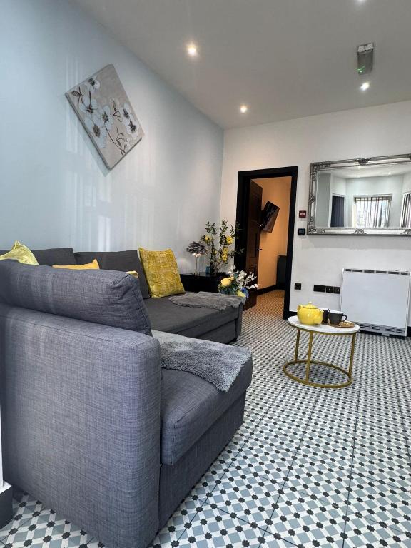 a living room with a couch and a table at Dove & Gold in Gloucestershire