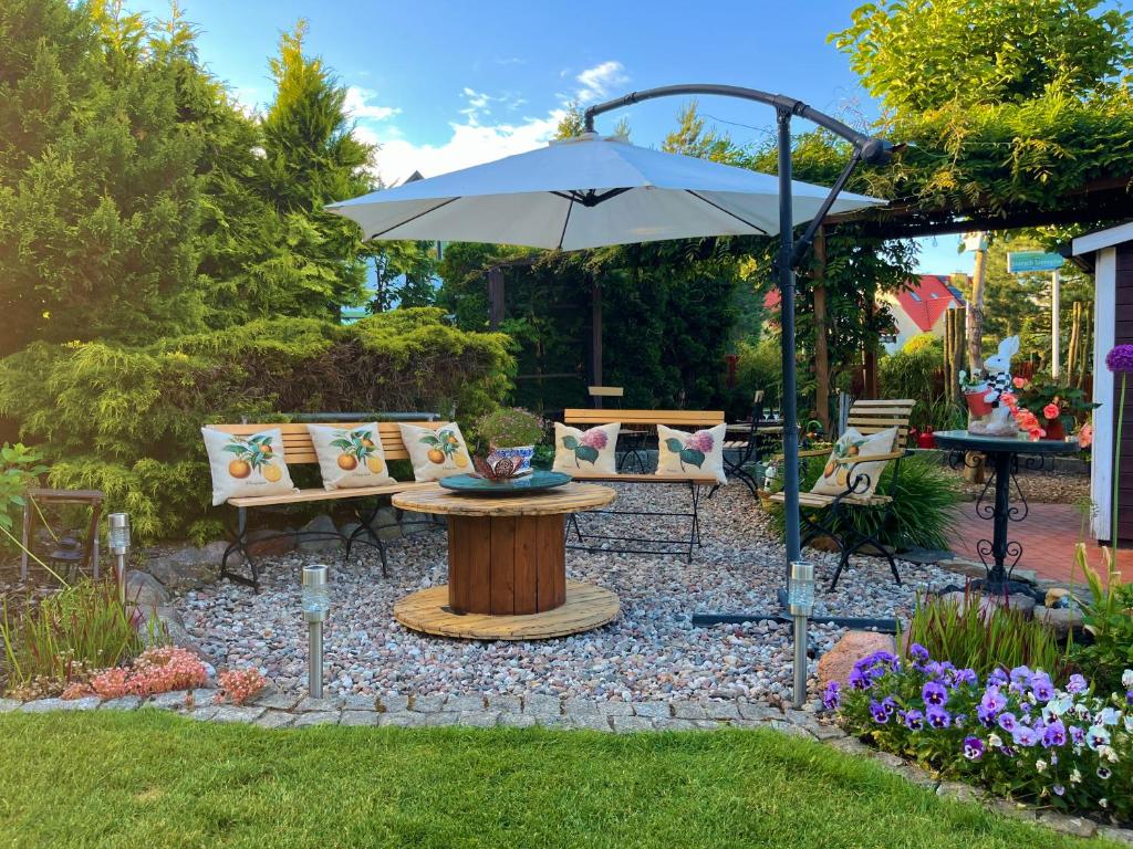 a patio with a table and an umbrella at Domek Lawenda z Ogrodem, konsolą PS4 z grami, Netflixem i Bezpłatnym Parkingiem in Szczecin