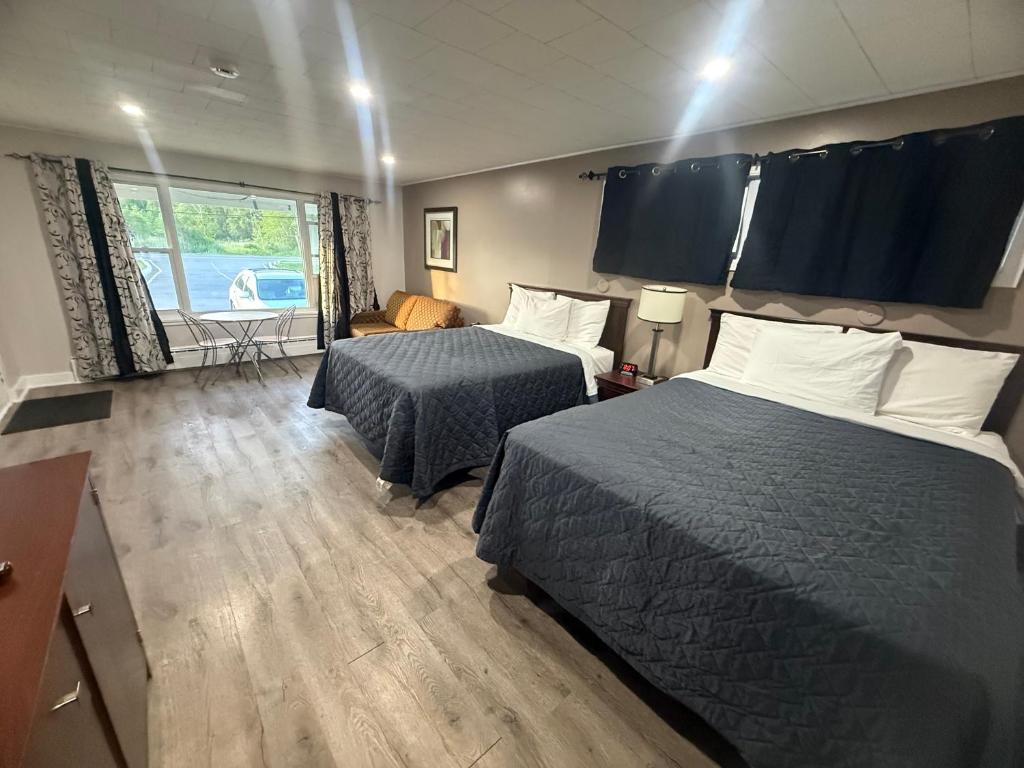 a hotel room with two beds and a window at Nites Inn Motel in Cornwall