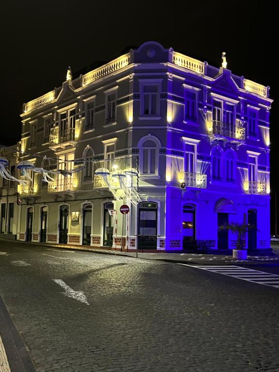 a large building is lit up in blue at night at Internacional Azores Boutique in Horta