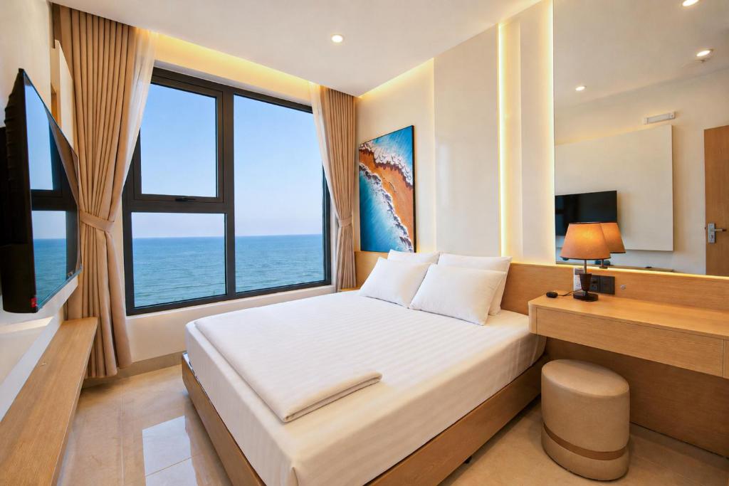 a bedroom with a bed and a desk with a window at The Pathway Condotel in Sầm Sơn