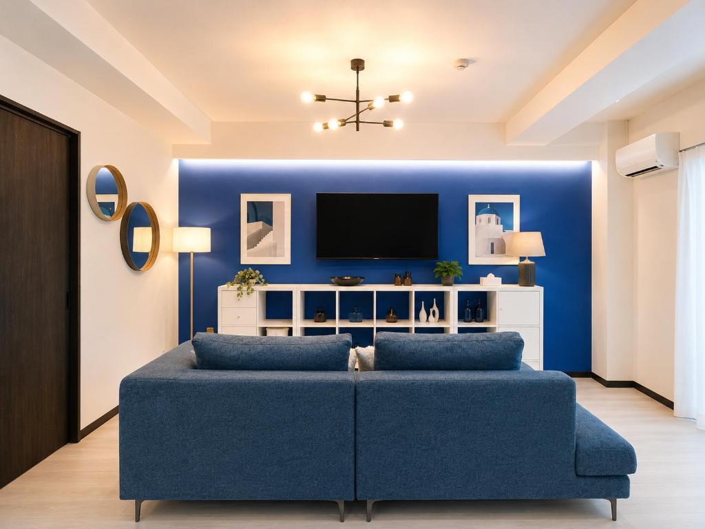 a living room with a blue couch and a tv at West Press Sasebo in Sasebo