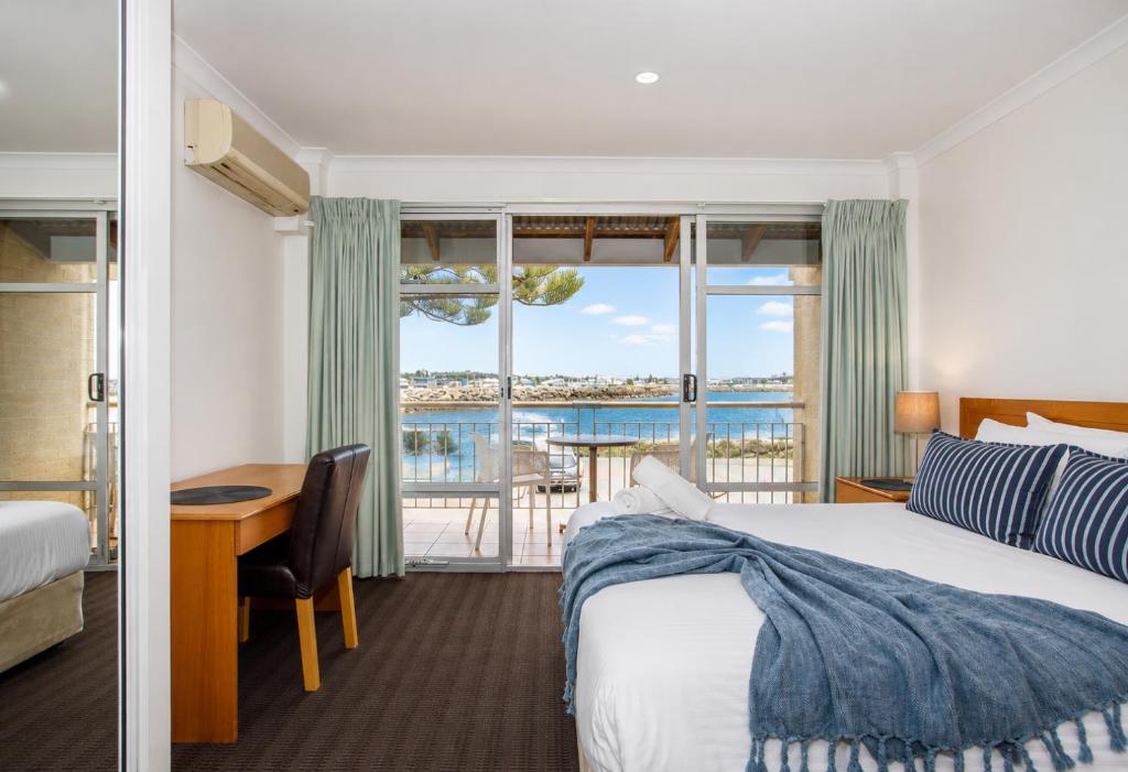 a hotel room with a bed and a view of the ocean at Mariners Lookout Absolute Harbour Views in Fremantle