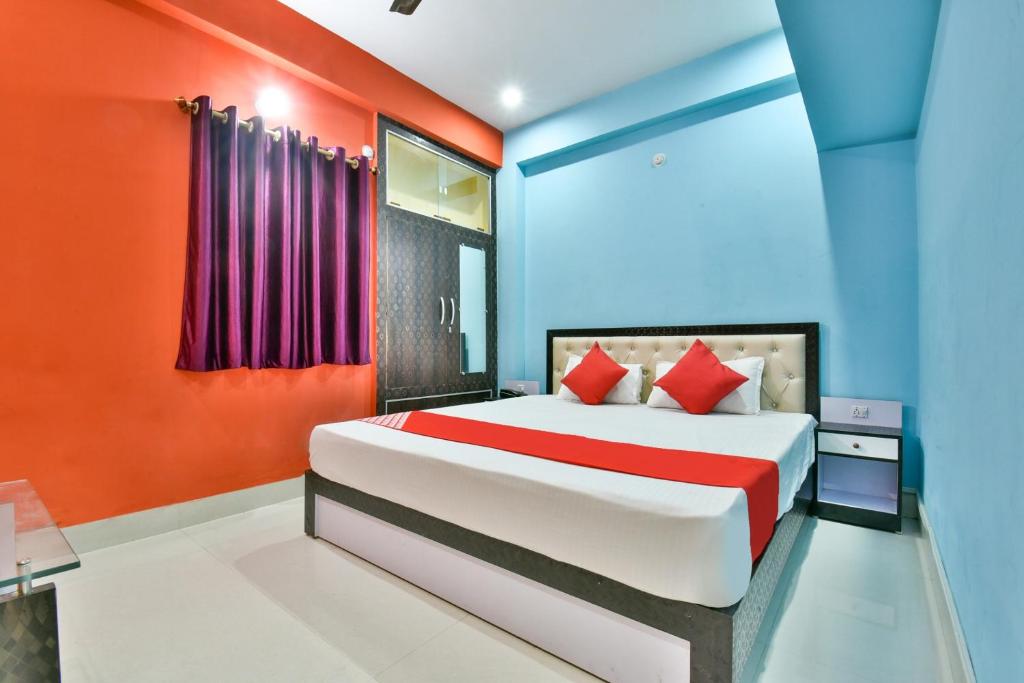 a bedroom with a bed with red and blue walls at Hotel O Magadh Imperial in Patna