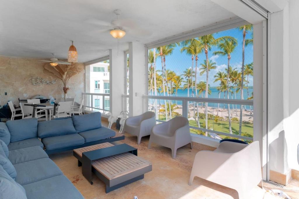 a living room with a blue couch and a view of the ocean at Beachfront Luxury Condo PGA Ocean View 4BR in Boca del Soco