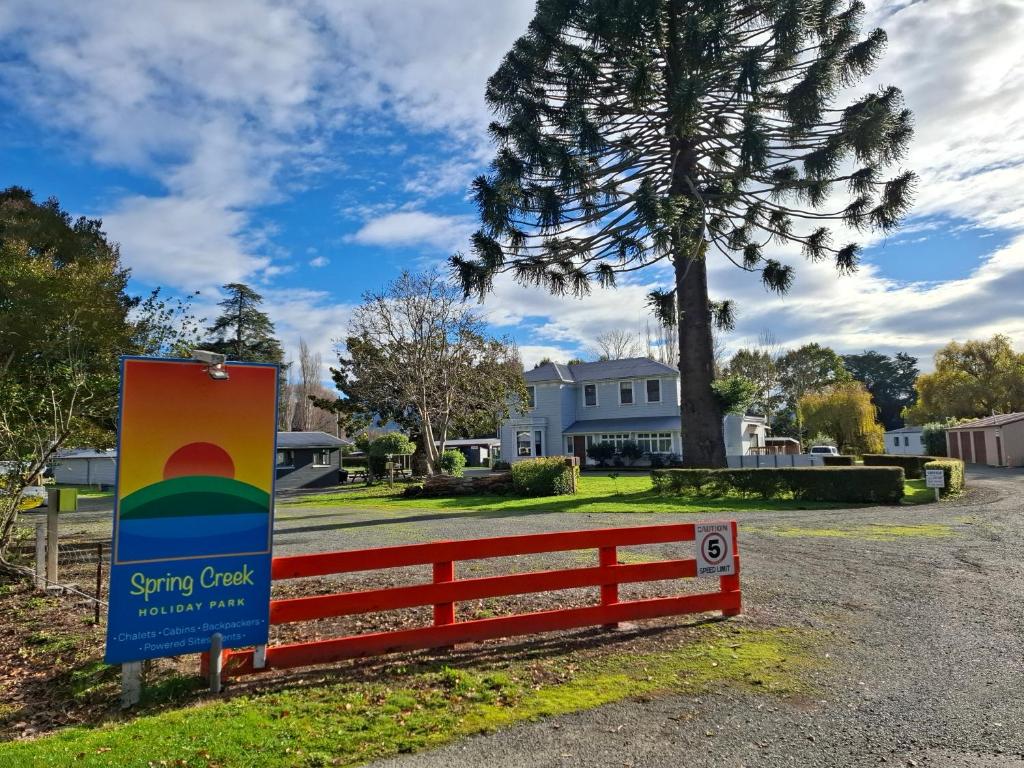 a sign in front of a yard with a house at Spring Creek Holiday Park in Blenheim