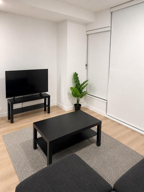 a living room with a black coffee table and a flat screen tv at Executive suit in Surrey