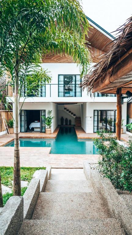 a house with a swimming pool and a palm tree at Bliss Villa By Happiness Philippines in El Nido
