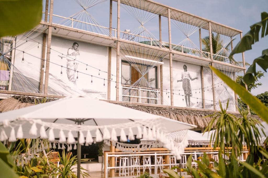 a building with an umbrella in front of it at Happiness Hostel Siargao in General Luna