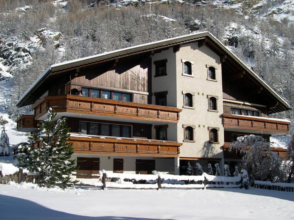 a large building with snow in front of it at Apartment Sunshine in Saas-Grund