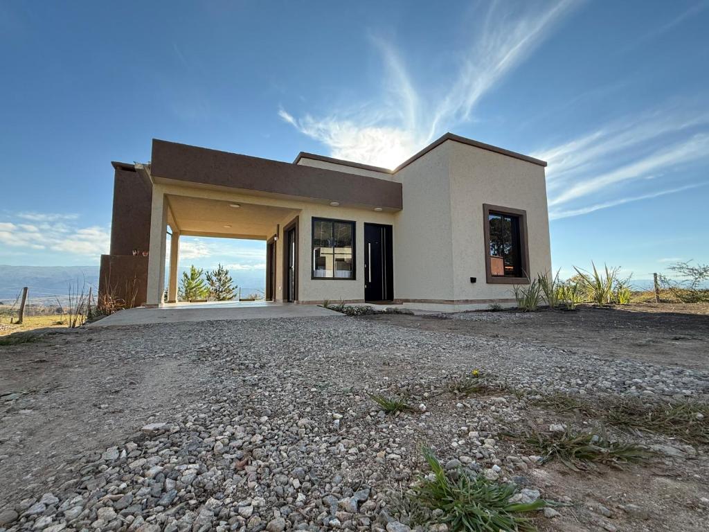 a house on a hill with a gravel driveway at El Tesoro de Yacanto in Villa Yacanto