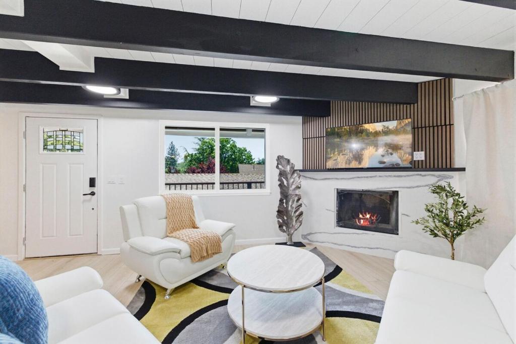 a living room with white furniture and a fireplace at Remodeled Yosemite Cabin Sleeps 12 in Groveland