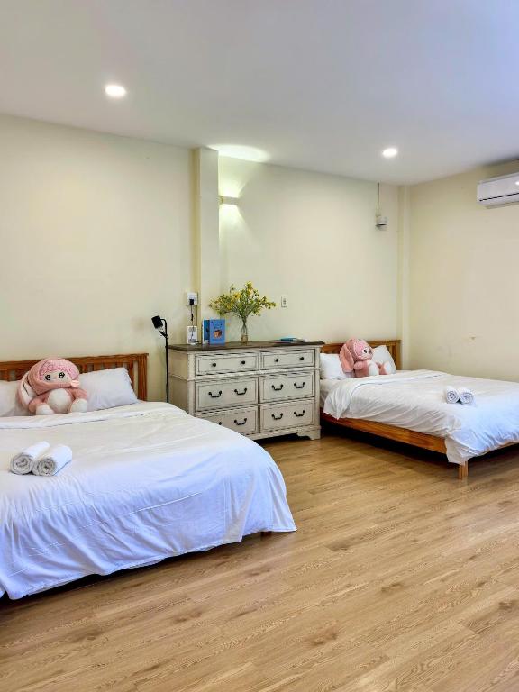 two beds in a room with pink dolls on them at Dune House Phan Thiết in Ấp Bình Hưng