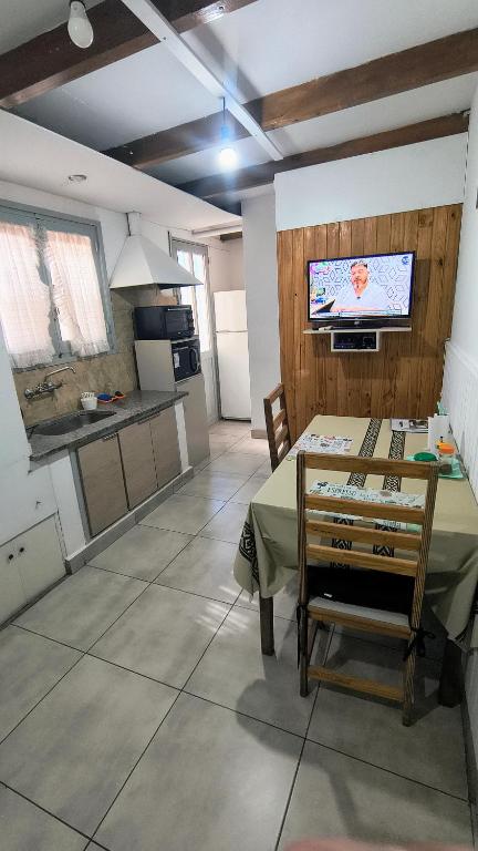 a kitchen and dining room with a table and a tv at TRINIDAD in San Juan