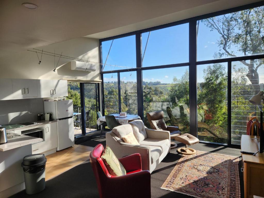 a living room with a lot of windows at Tamar Ridge Winery Apartments in Grindelwald