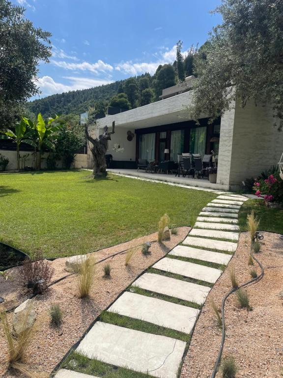 a garden with a stone path leading to a house at Krum's Little Secret Villa in Vourvourou