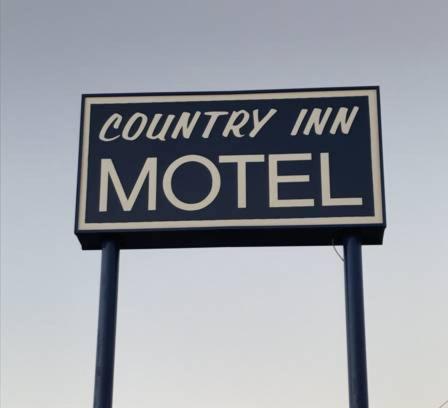 een straatbord met de tekst Country Inn motel bij Country Inn Motel in Waukomis