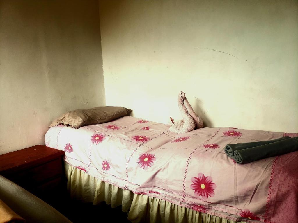 a bedroom with a bed with pink flowers on it at Renta Rey David in Caracas