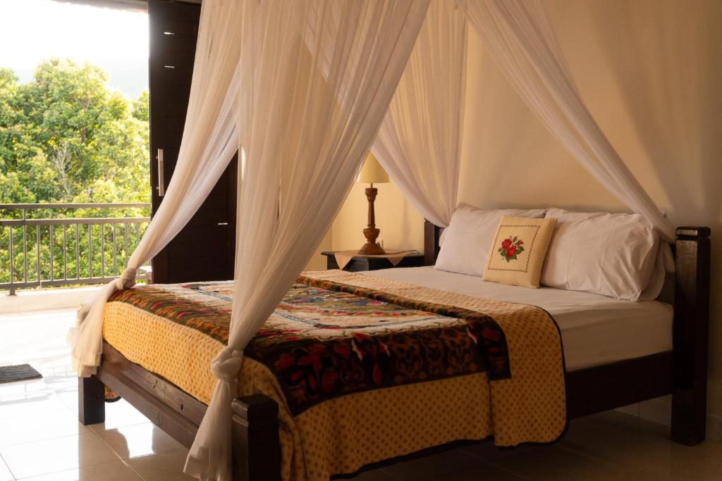 a bedroom with a canopy bed with a balcony at Dangin Mangkalan Homestay in Munduk