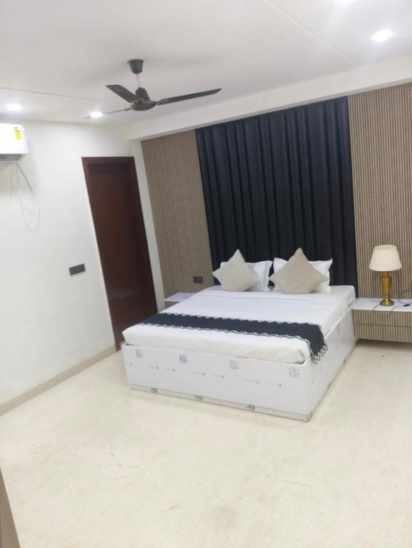 a bedroom with a white bed and a ceiling fan at Bell Rooms Hotel in Noida