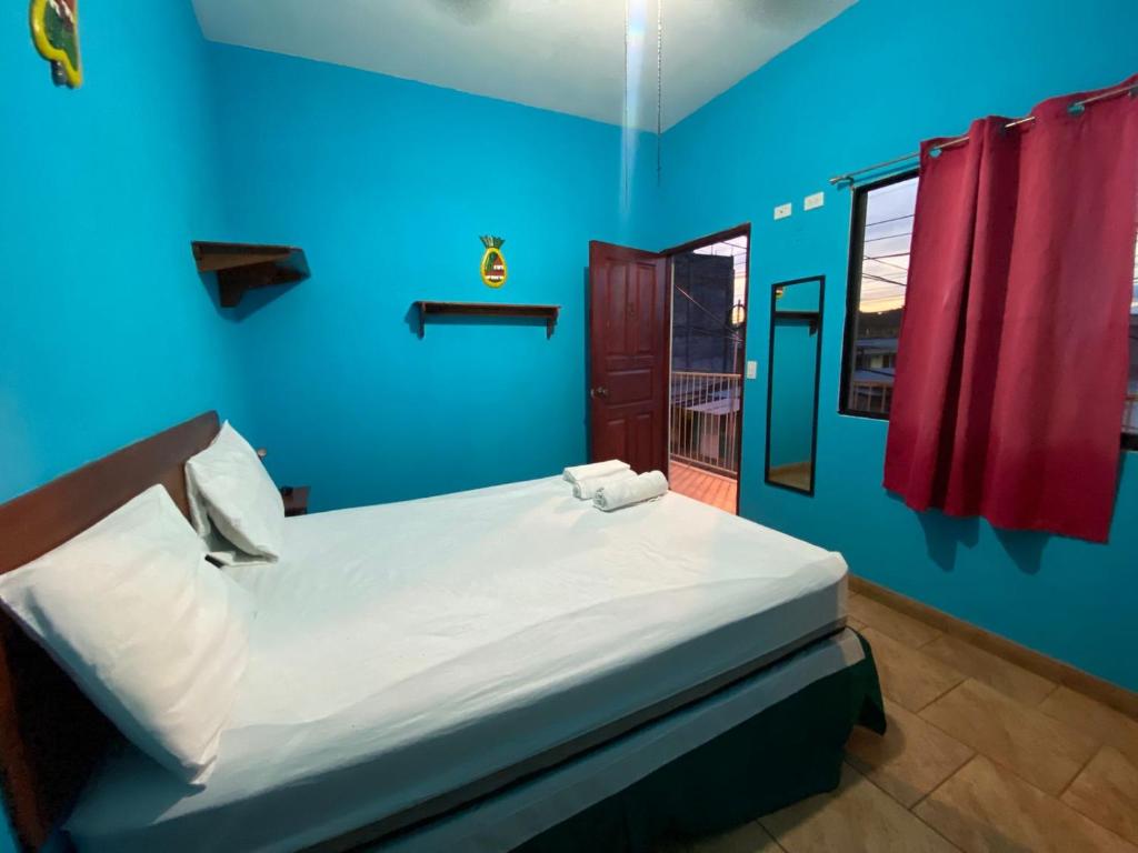 a blue bedroom with a bed with two towels on it at Hotel del Sur in San Juan del Sur