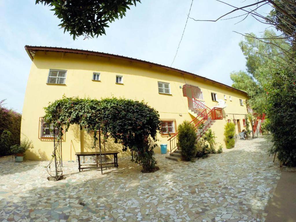 un edificio giallo con una panchina davanti di Sanchaba Yellow Apartments a Kololi