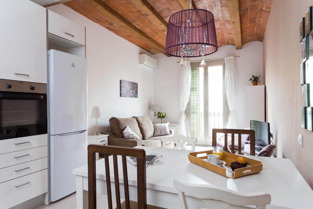 een keuken en een woonkamer met een tafel en stoelen bij Casa Cosi Letamendi in Barcelona