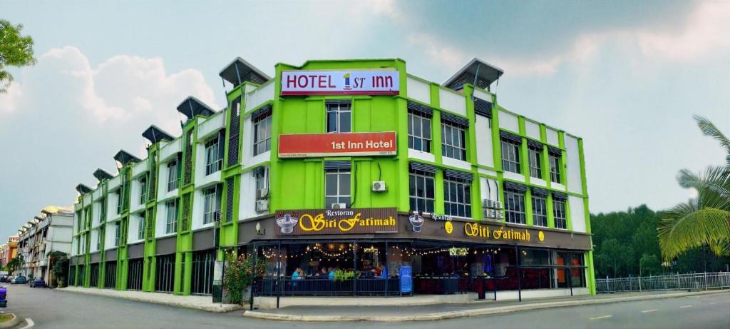 a green building with a sign that reads hotel us inn at 1st Inn Hotel Klang Sentral Meru in Klang