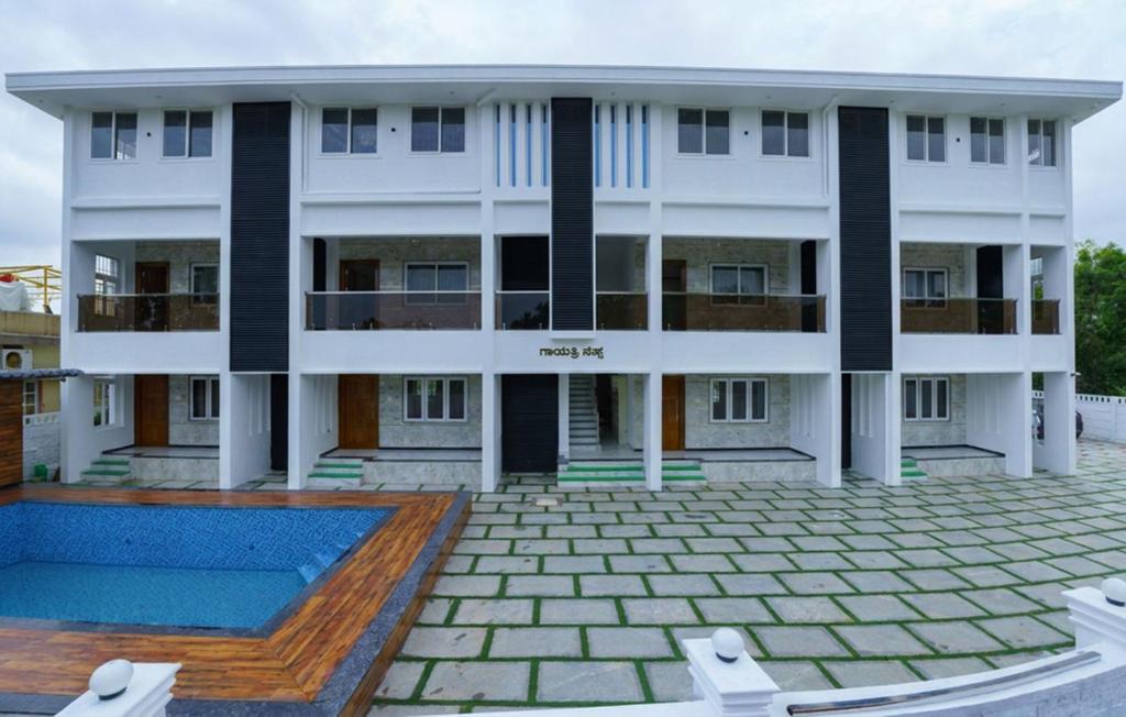a building with a swimming pool in front of it at Gayathri Nest in Udupi