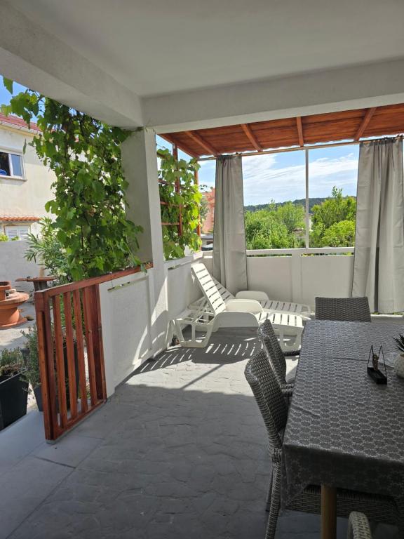 a patio with a table and chairs on a balcony at 6 M, 50 m do plaže in Barbat na Rabu