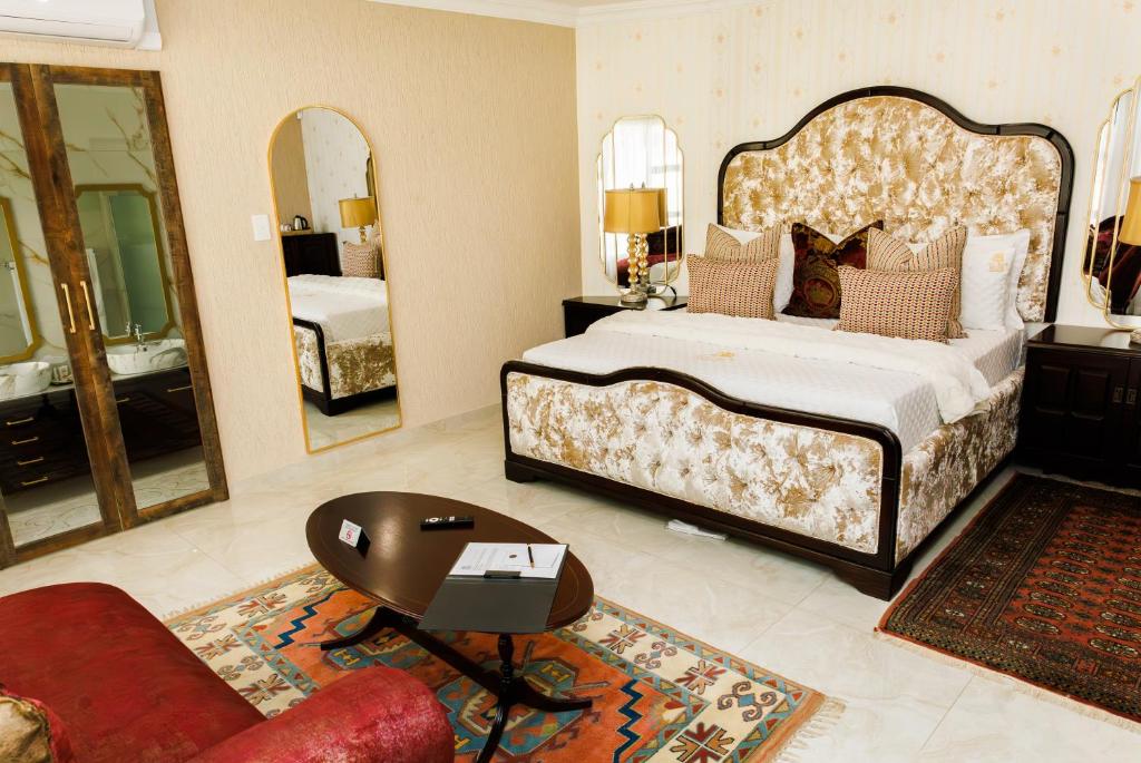 a bedroom with a large bed and a large mirror at Jul Rick House Guesthouse in Sandton