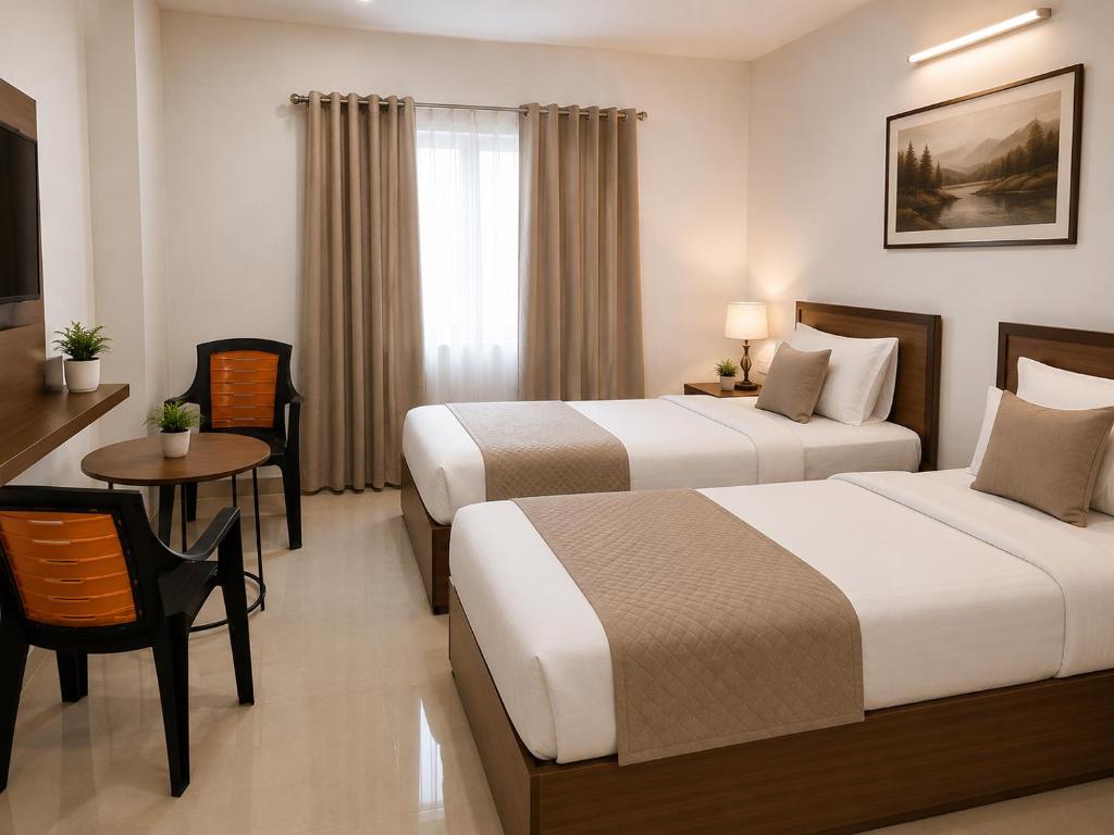 a hotel room with two beds and a table at Heritage Garden in Bānsjora