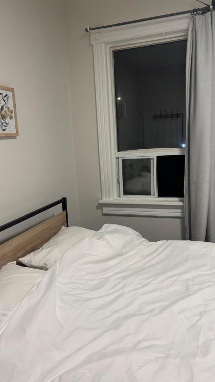 a white bed in a bedroom with a window at Casa Toronto in Toronto