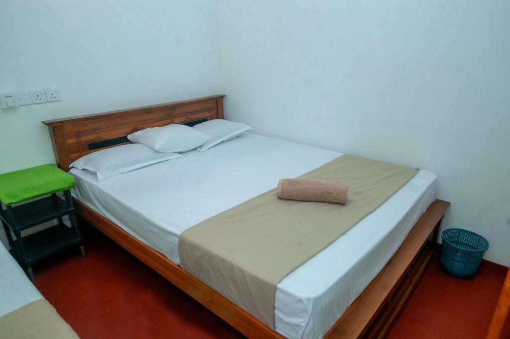 a bedroom with a large bed with a wooden headboard at Zenvora Rainforest Villa in Deniyaya