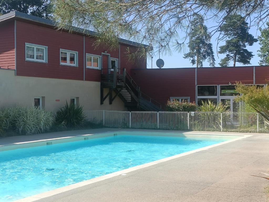 a swimming pool in front of a house at Cottage Mansart piscine tout équipé in Chaveignes