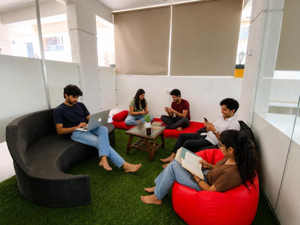 a group of people sitting in chairs in a room at Joy Suites and Hostel in Pune