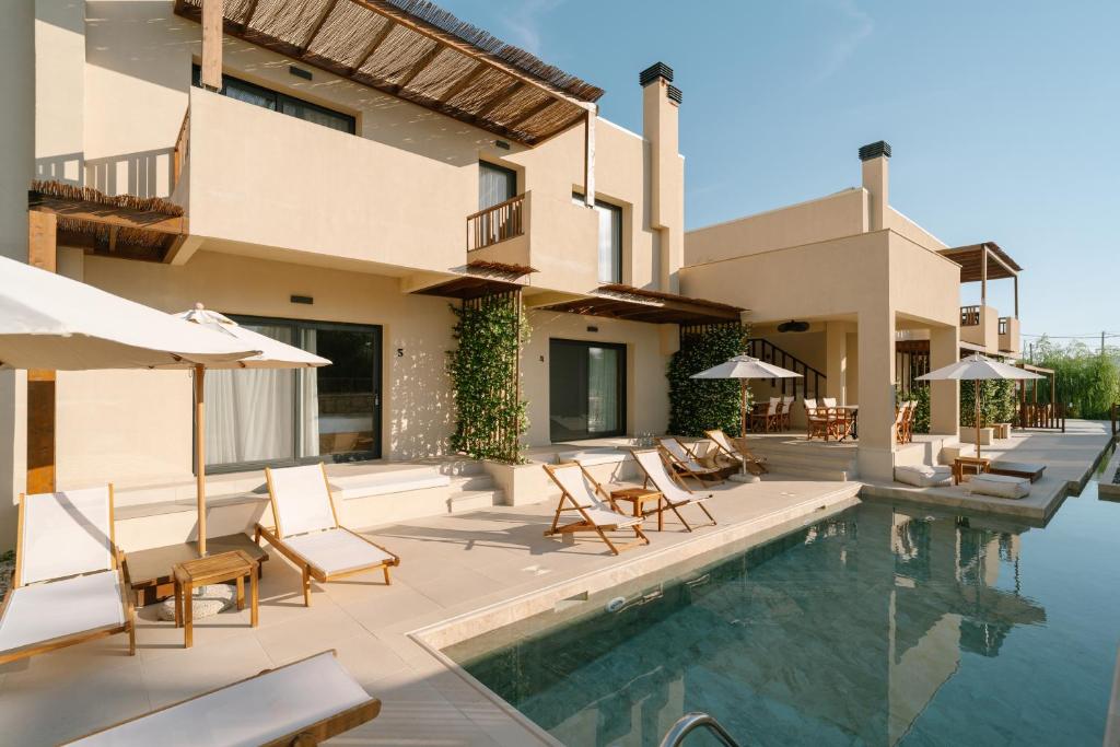 a house with a swimming pool with chairs and umbrellas at Atman Eco Lodge in Gliki