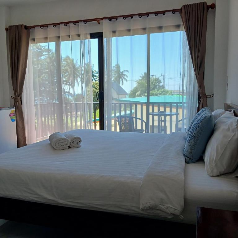 a bed with towels on it with a large window at First light beach hin kong in Hinkong