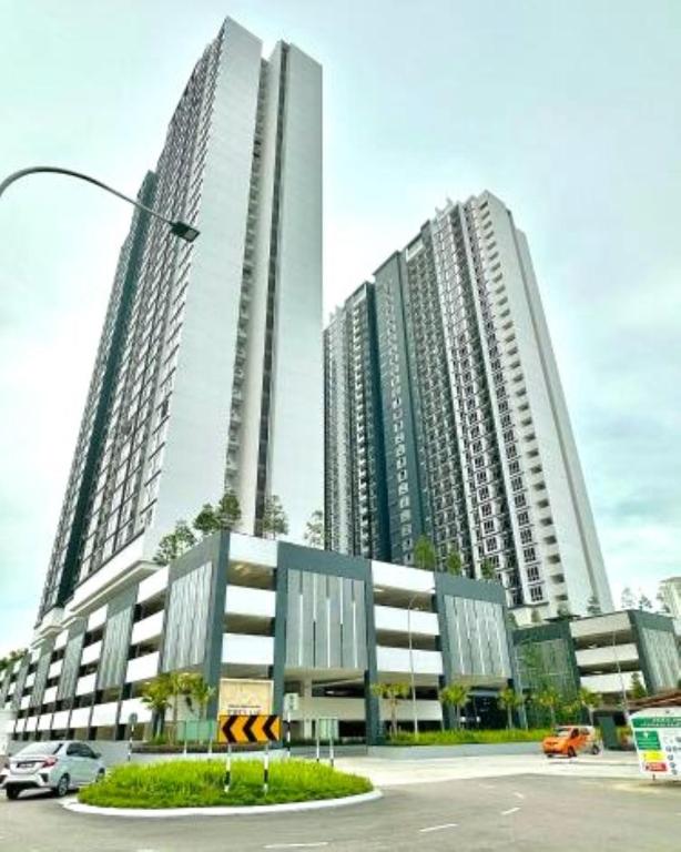 two tall buildings with cars in a parking lot at Trellis Residence by RR JBcity in Johor Bahru