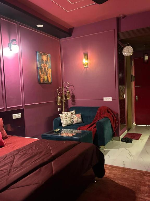 a purple room with a bed and a couch at THE MOONLIGHT STUDIo in Ghaziabad